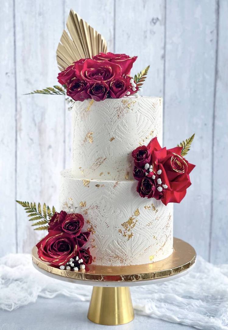 Two-tier cake with claret roses and a gold palm frond, Hyderabad